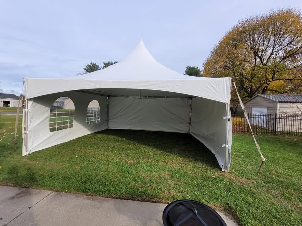 White high-peak frame tent with solid and window sidewalls set up on a residential lawn